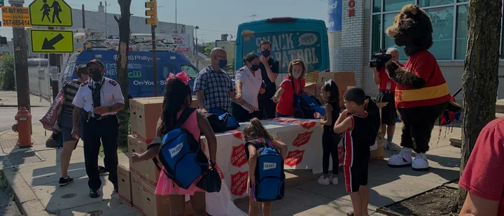 Herr's volunteers distributing backpacks to local families in need